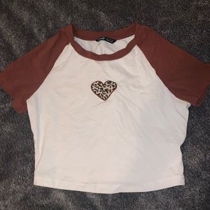 Cropped white shirt with brown sleeve. And cheetah print heart.